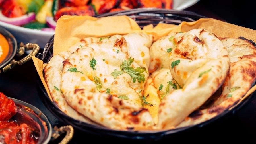 Fluffiges Butter-Naan, direkt aus dem Ofen, serviert mit würzigem Curry – ein Genuss, der an Restaurantbesuche und Feste erinnert.